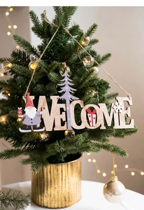 Detailed view of wood 'WELCOME' sign with gnome and tree hanging on a glowing Christmas tree