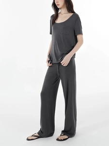 Detail of soft charcoal grey wide-leg trousers and matching pocket tee with drape texture