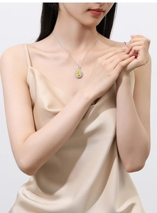 Detail of water drop yellow pear-cut diamond pendant necklace on a female model