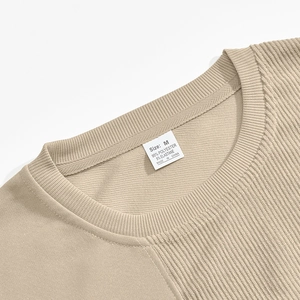 Detail of ribbed neckline and fabric label on khaki corduroy patchwork sweatshirt