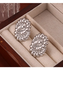 Close-up of silver-toned oval sunflower earrings with radial texture in jewelry box
