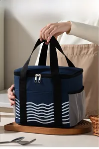 Detail of insulated lunch bag with wave pattern and mesh side pocket held by hand