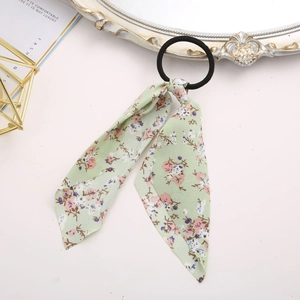 Detail of light green floral silk scarf scrunchie on a decorative vintage background