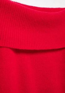 Detailed close-up showing the red knitted fabric and ribbed neckline texture of the sweater