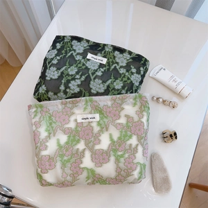Detailed view of floral embroidery on sheer mesh pouches with Simple Wish logo label