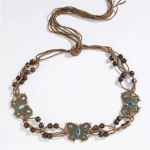 Detail of woven brown rope belt with wooden beads and bronze butterfly crystal accents
