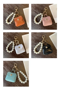 Close-up of mini crocodile pattern leather keychain bags with large pearl handles in five colors