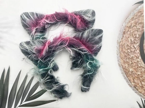Detail view of plush wolf ears headband with grey, pink, and cyan gradient faux fur texture