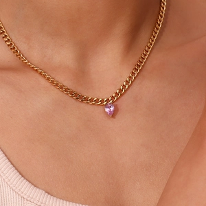 Close-up of a gold Cuban chain necklace with a pear-shaped pink purple zircon pendant