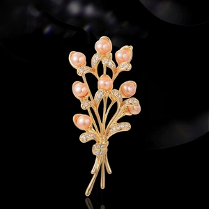 Elegant gold wheat brooch with pink freshwater pearls and crystals on black background