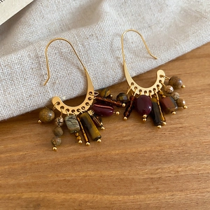 Detail of 18k gold plated fringe earrings with vintage stone beads on burlap