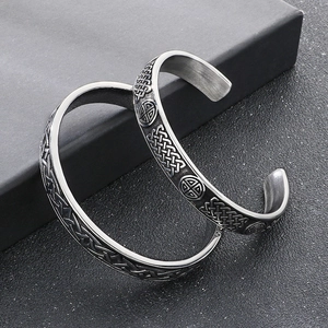 Close-up of vintage titanium steel bangle with intricate Celtic knot and totem reliefs