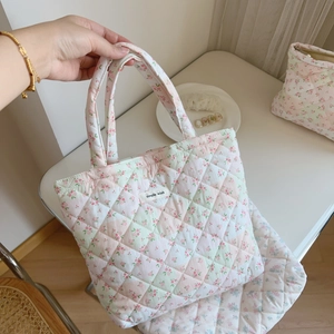 Close-up of pink floral quilted cotton handbag featuring a woven Simple Wish label