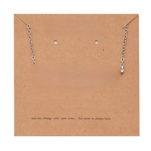 Detail of silver Sagittarius zodiac pendant necklace on a decorative brown paper card