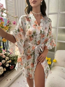 Détail d'un peignoir en satin à fleurs avec col en V et manches évasées dans un jardin