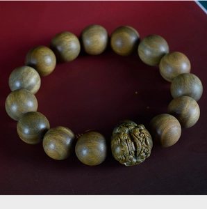 Macro detail of sandalwood beads showing natural wood grain and a carved charm