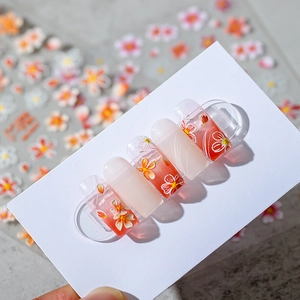 3D floral nail art stickers in fresh pink and orange tones on translucent nails