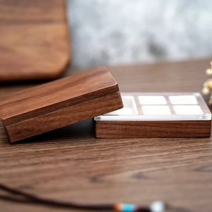 Macro shot of walnut jewelry box showing natural wood grain and interior compartments