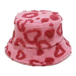 Detail of pink faux shearling bucket hat featuring fluffy texture and heart patterns