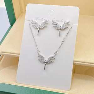 Detail of silver angel wing jewelry set with rhinestones in a green display box