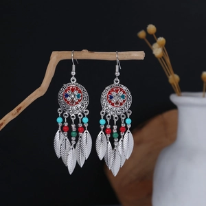 Macro detail of bohemian silver tassel earrings with colorful beads and metal feathers