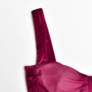 Detail der burgunderroten Samtträger und gefalteten Netzcups an einem sexy Partykleid