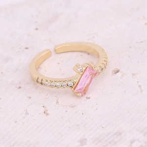 Detailed view of adjustable gold ring featuring a pink rectangular stone and side zircons