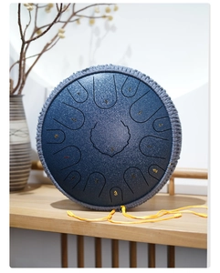 Detailed view of a deep blue steel tongue drum with numerical notes and braided rope decor
