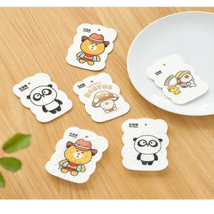 Flat lay of compressed wood pulp sponges with cute cartoon animal prints on wood table