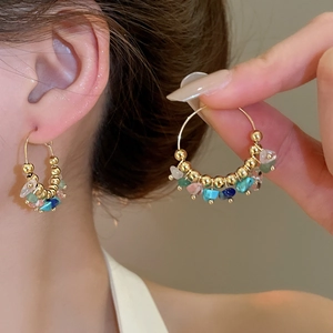 Detailed close-up of Bohemian gold hoop earrings featuring colorful natural stone beads