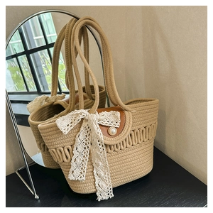 Detail of woven straw tote bag with elegant lace bow and decorative pearl button