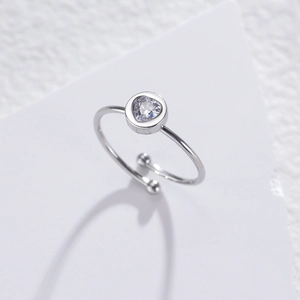 Macro shot of silver stainless steel open ring with heart-shaped zircon inlay