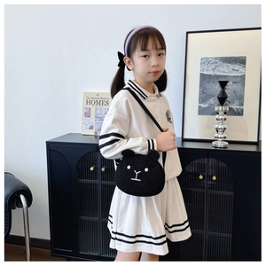 Toddler in striped knit dress wearing a cute black plush bear crossbody bag