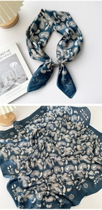 Detail of teal satin neck scarf with paisley pattern on white background