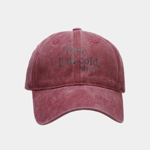 Detail of burgundy washed cotton baseball cap with Yes I'm Cold slogan print