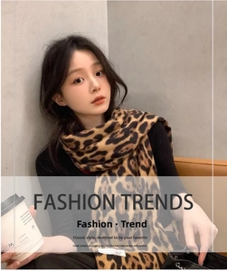 Detailed close-up of leopard print scarf material texture and soft faux cashmere tassels
