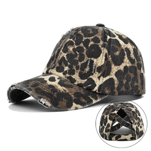 Detail view of leopard print baseball cap featuring distressed holes and ponytail hole