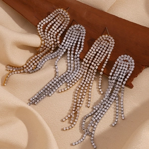 Detailed macro view of 18K gold and silver tassel earrings with micro-set zircons