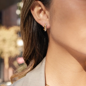 Golden double layered twisted C-hoop earrings with rhinestones on model in sunlight