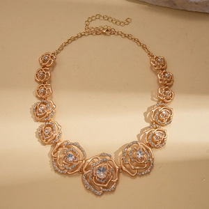 Detailed close-up of hollow rose necklace with sparkling rhinestones and golden finish