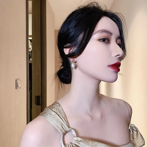 Gros plan de boucles d'oreilles rétro avec pierres œil de chat portées par un mannequin