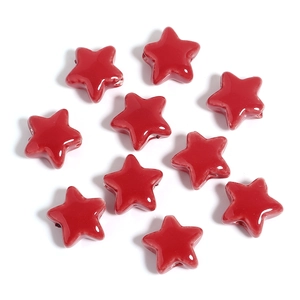 Close-up of bright red star-shaped ceramic beads with smooth glazed finish for DIY jewelry