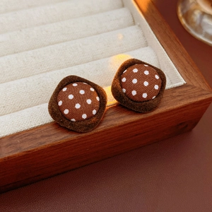 Macro shot of brown polka dot fabric earrings with square flocked borders and silver pins