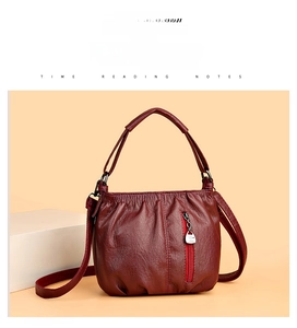 Detailed macro view of soft dark red pleated leather texture with silver metal zipper pull