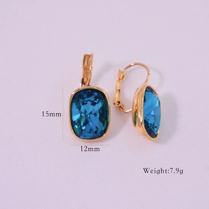Detailed view of 14K gold-plated hoop earrings with 15mm oval blue crystal settings