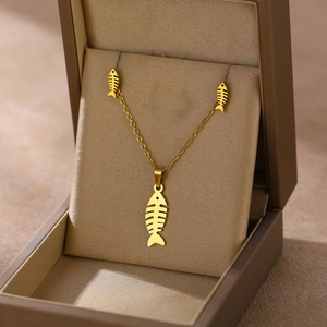 Golden fishbone pendant necklace and earrings set showcased in a beige jewelry gift box