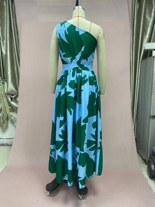 Detail of one-shoulder tropical leaf print dress with emerald and azure color blocking