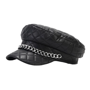 Chic black quilted faux leather baker boy hat featuring a decorative silver metal chain