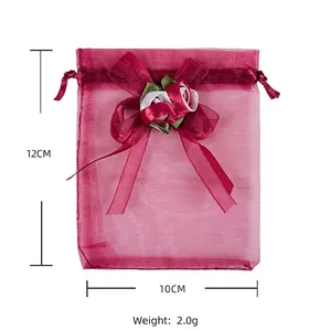 Detailed view of red organza drawstring gift bag with rose bow, size 12x10cm, weight 2.0g