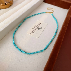 Détail macro du collier de perles turquoise avec fermoir mousqueton doré et extension
